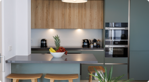 Vue de la cuisine (plan de travail, four, frigo, placards)